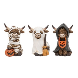 Three resin Highland cow figures dressed as a mummy, a ghost, and a hooded cloak with Halloween pumpkins